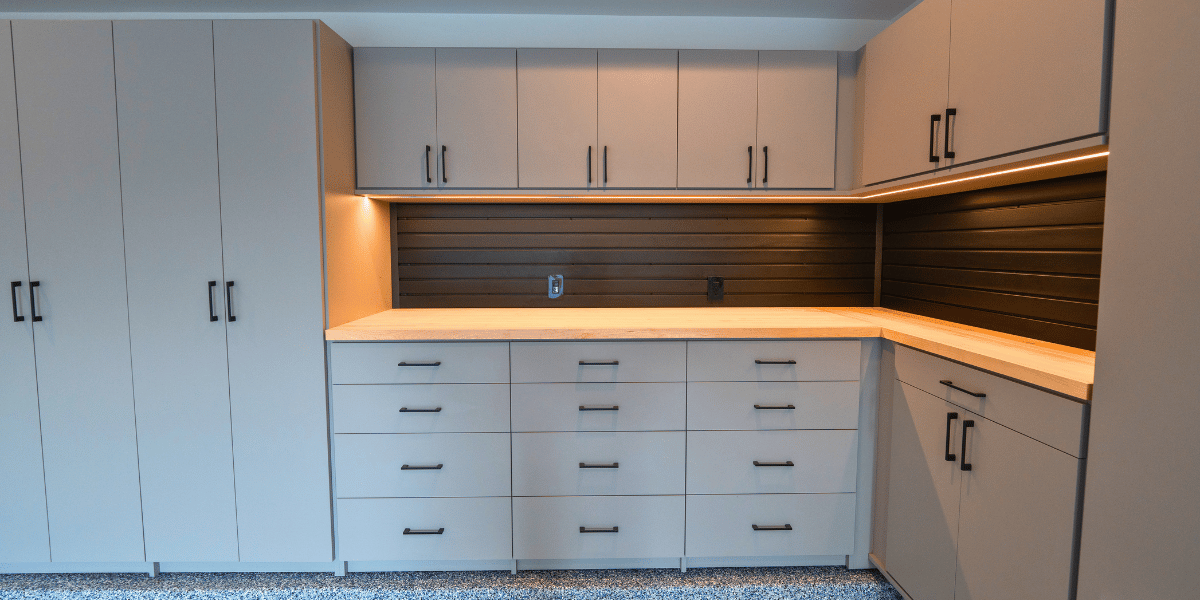 Garage custom cabinets with built-in workspace and slatwall organization designed by SpaceManager Closets 