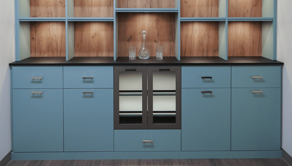Custom built-in featuring blue cabinets and warm wood backing with wine fridge designed by SpaceManager Closets