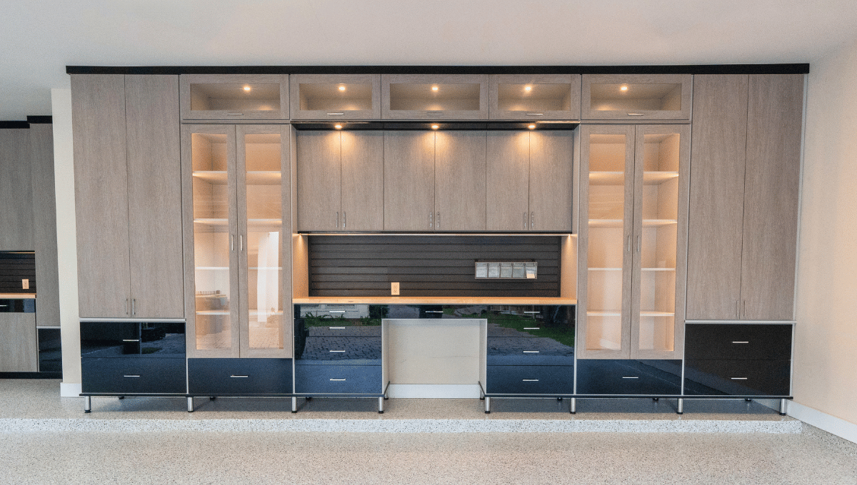 Custom garage storage system with built-in cabinets, display shelves, slatwall organization - designed by SpaceManager Closets