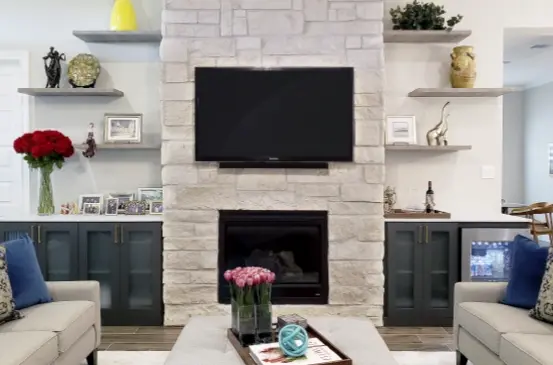 Built-in entertainment center surrounding a fireplace with custom cabinetry, floating shelves, and media storage.